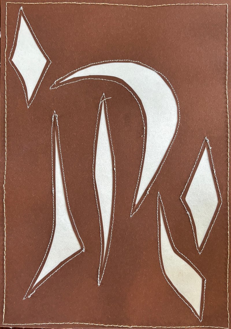 Brown paper with cream cut-out shapes, sewn onto satin